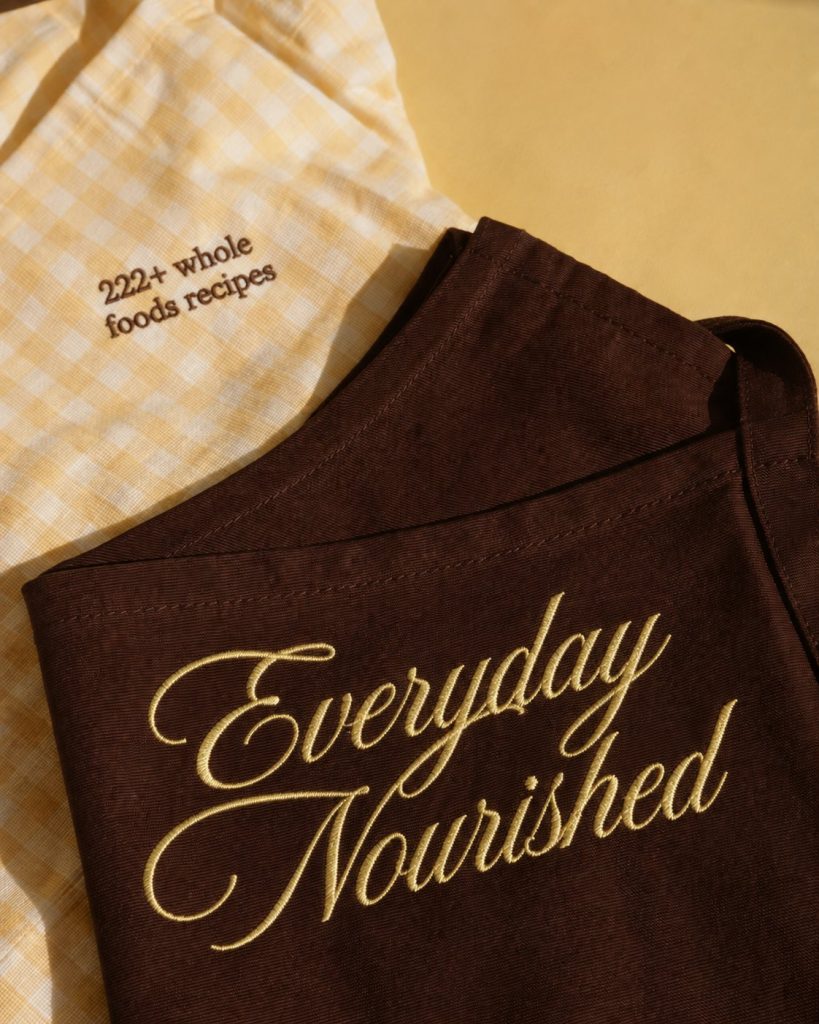 Everyday Nourished cookbook wrapped in yellow gingham cloth with ribbon